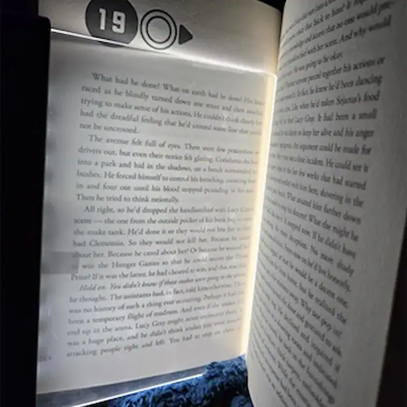 Femme qui lit la nuit avec la LucidLens pendant que le partenaire dort
