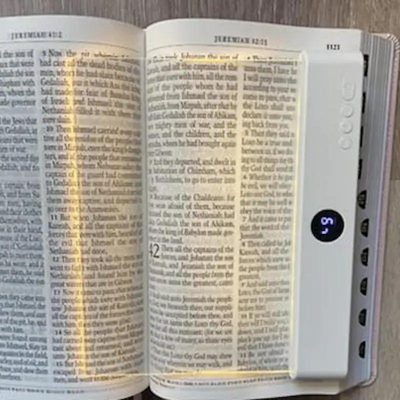 Femme qui lit un livre avec la LucidLens avant de dormir