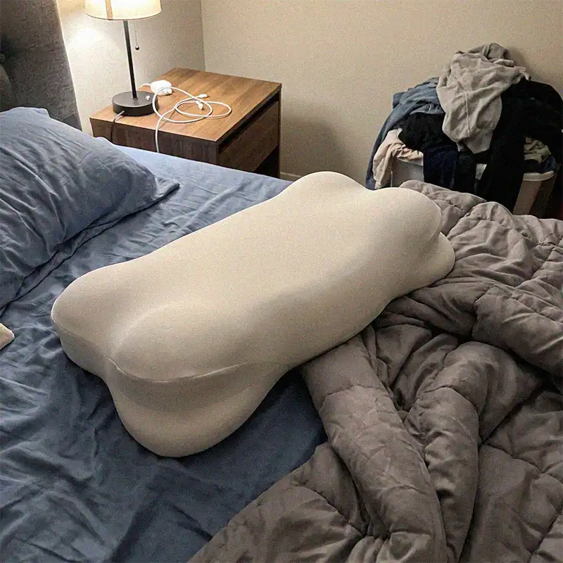 Oreiller CloudNest avec contour cervical sur un lit